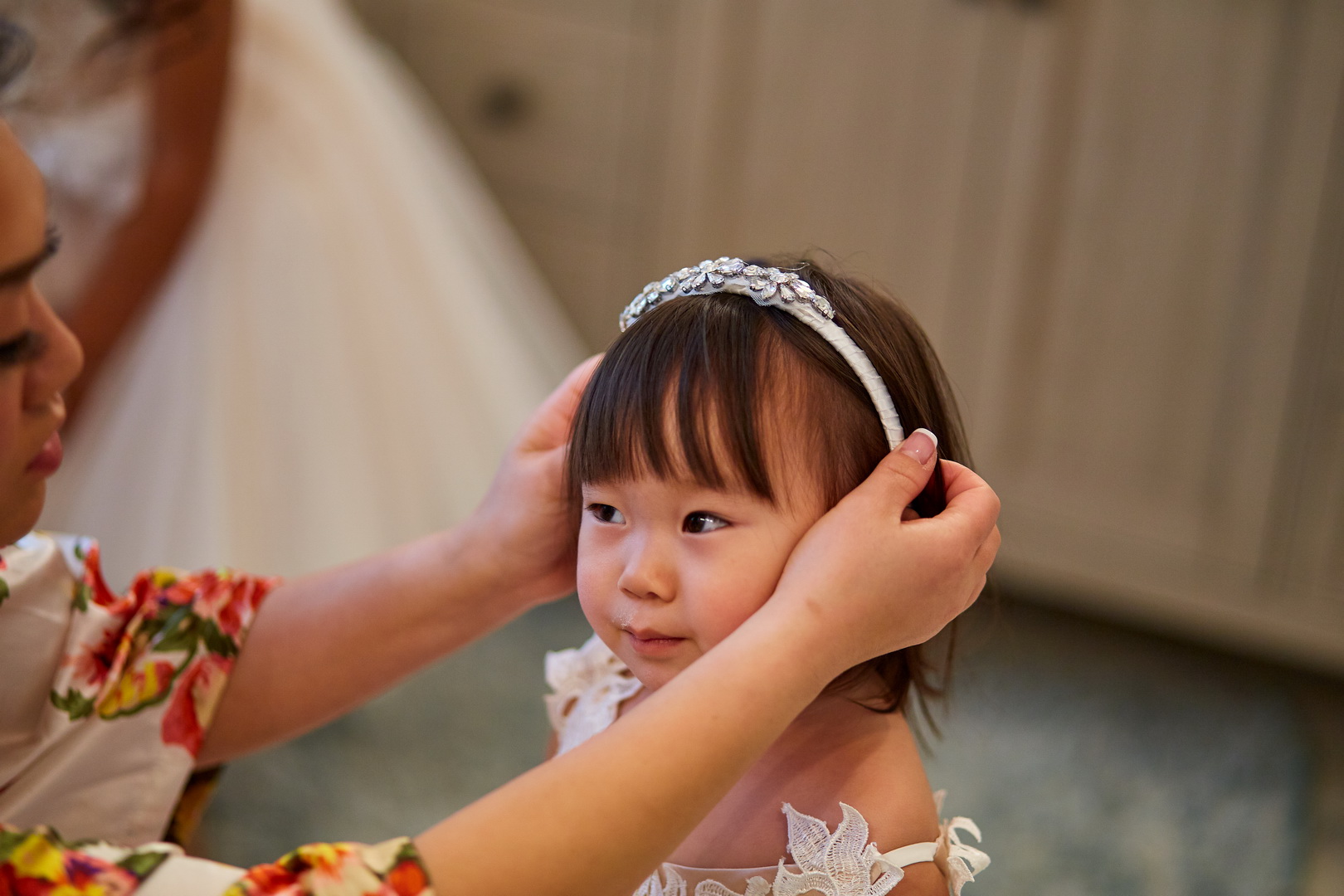 Bride helping flower girl daughter with crystal headband tiara