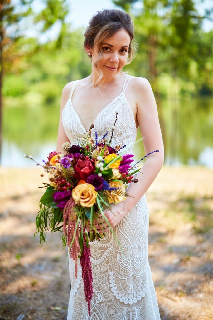 Bride in lace dress with colorful bouquet in Charleston Woodlands