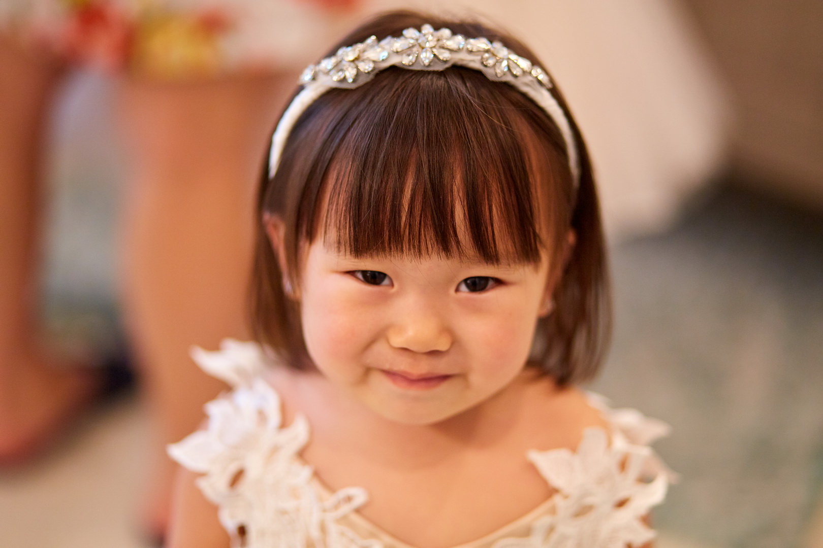 Portrait of flower girl wearing lace dress and crystal headband tiara