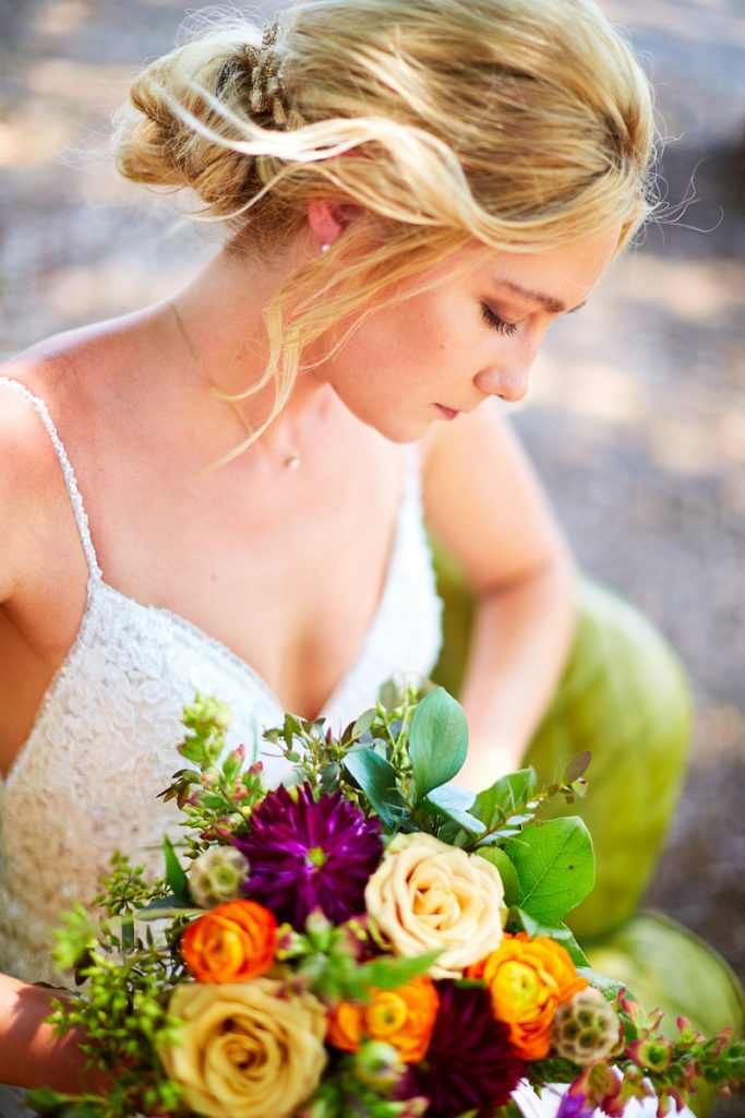 Detail of bride looking down at colorful bouquet