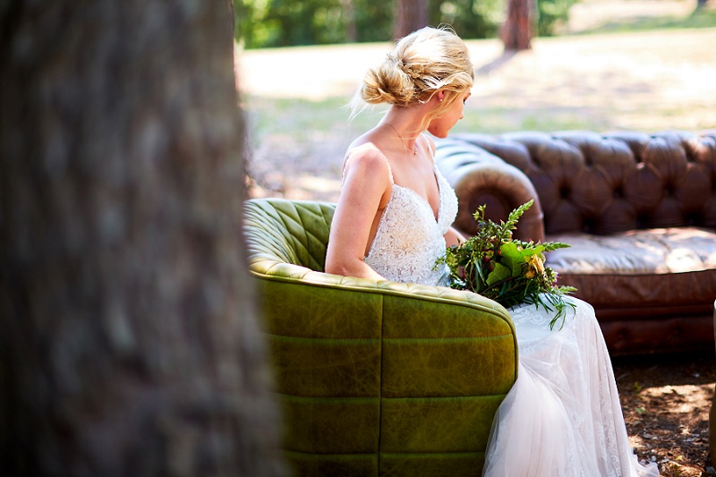Bride looking away. lounging on brown couch at Charleston Woodlands