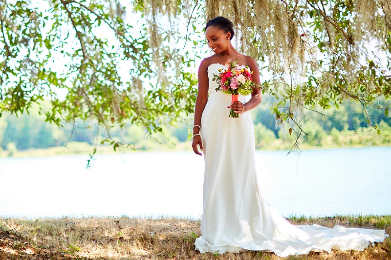 Bride under oak trees with spanish moss, lakeside