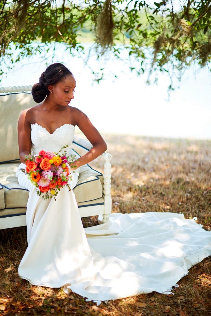 Bride lounging and looking over her shoulder, with colorful bouquet at Charleston Woodlands