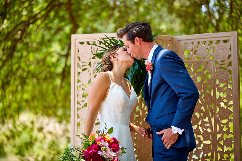 Bride and groom kiss at Charleston Woodlands wedding ceremony arbor