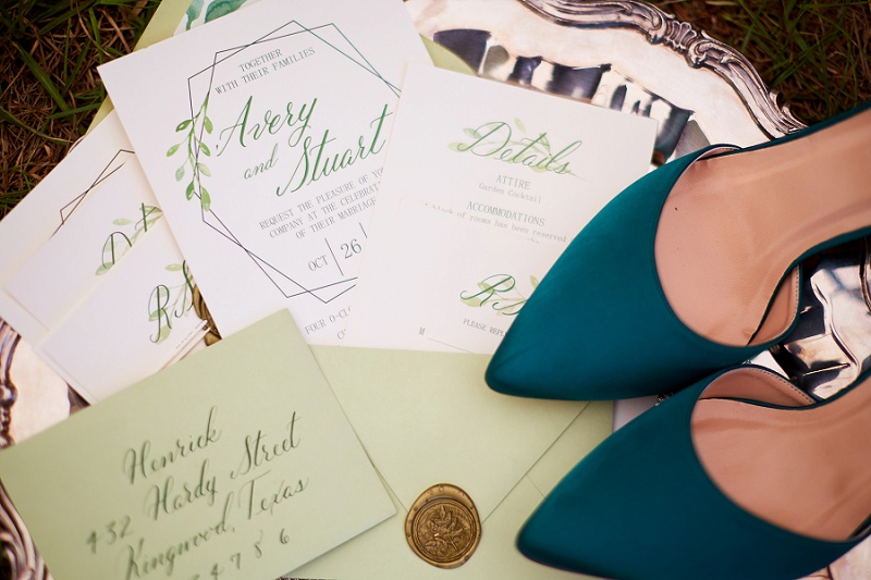 Detail of green shoes and wedding invitation