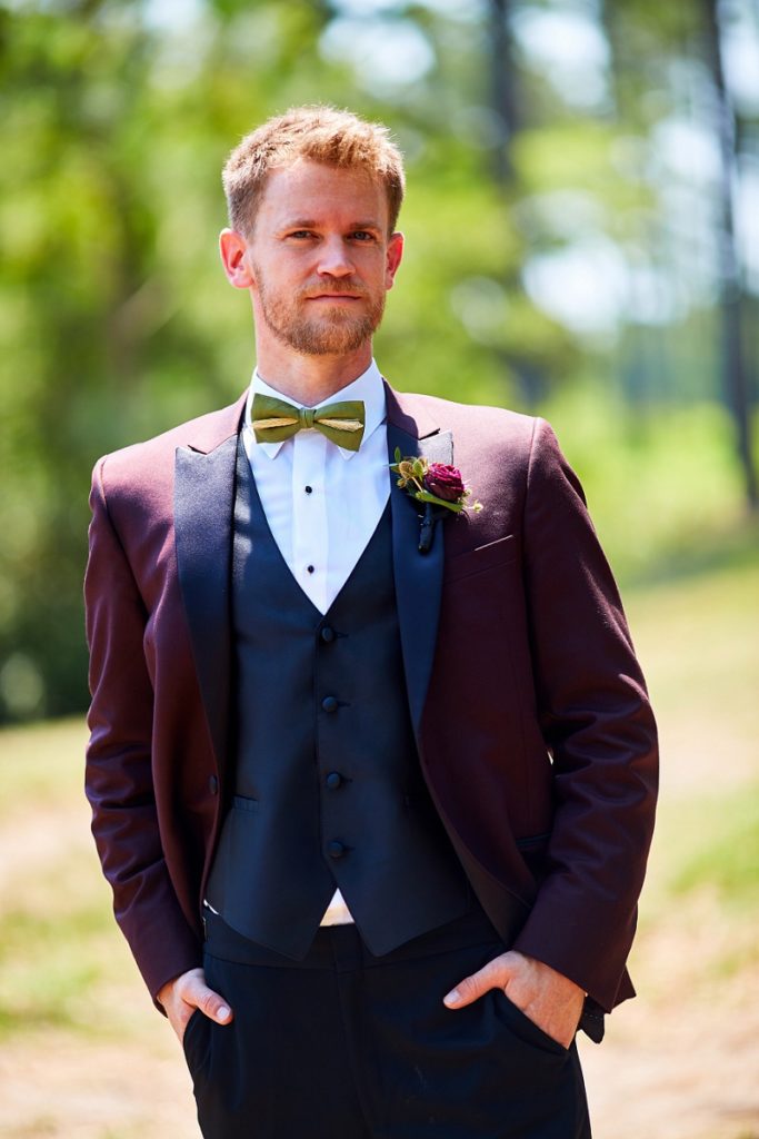 Portrait of groom in burgundy tuxedo at Charleston Woodlands