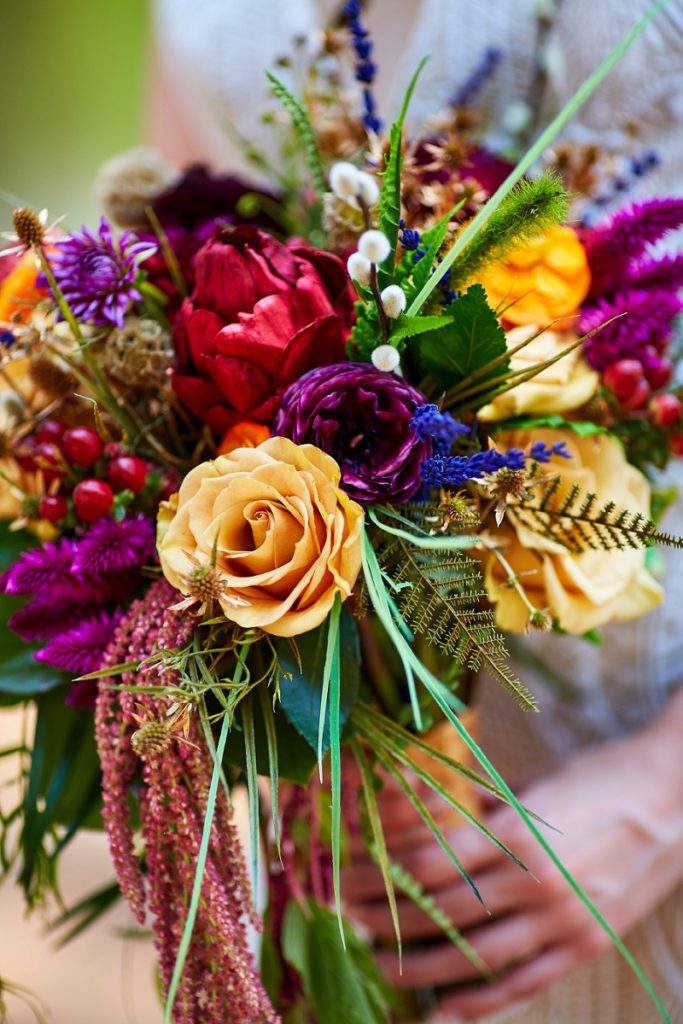 Close up detail of bridal bouquet with yellow rose and other colorful flowers