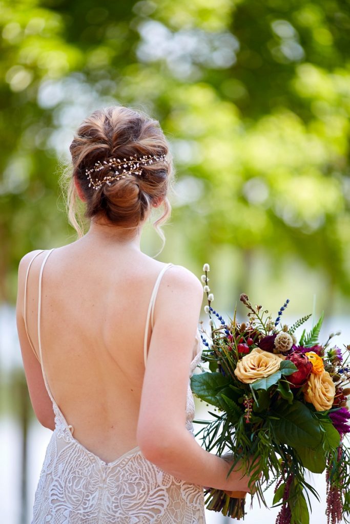 Bride hair and hairpiece detail, while holding colorful bouquet