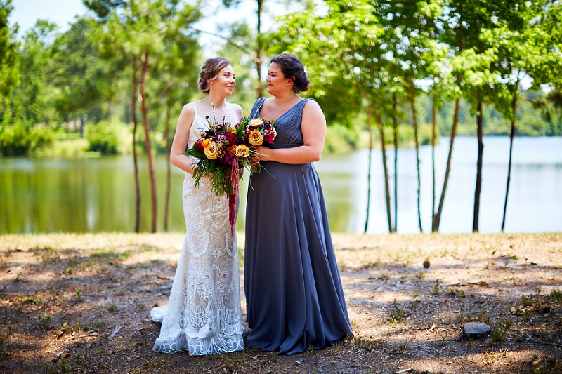 Bride and bridesmaid talking and holding colorful bouquets