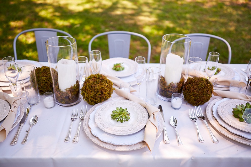 Natural wedding reception table design with succulent accents and acrylic place cards.