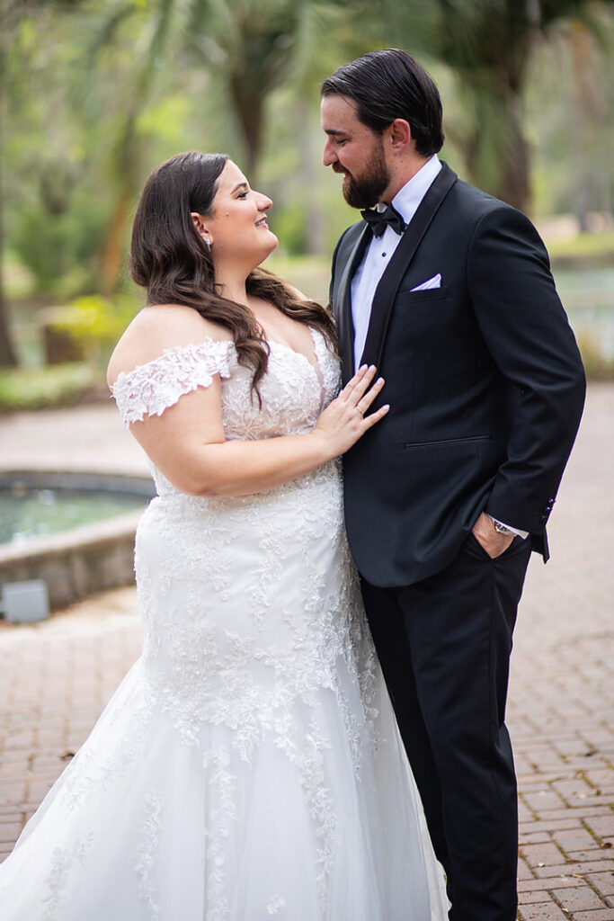 Portrait of bride and groom looking at each other at Eden at Gracefield garden fountain - photographed by Charleston wedding photographer Luxe By Lindsay Photography