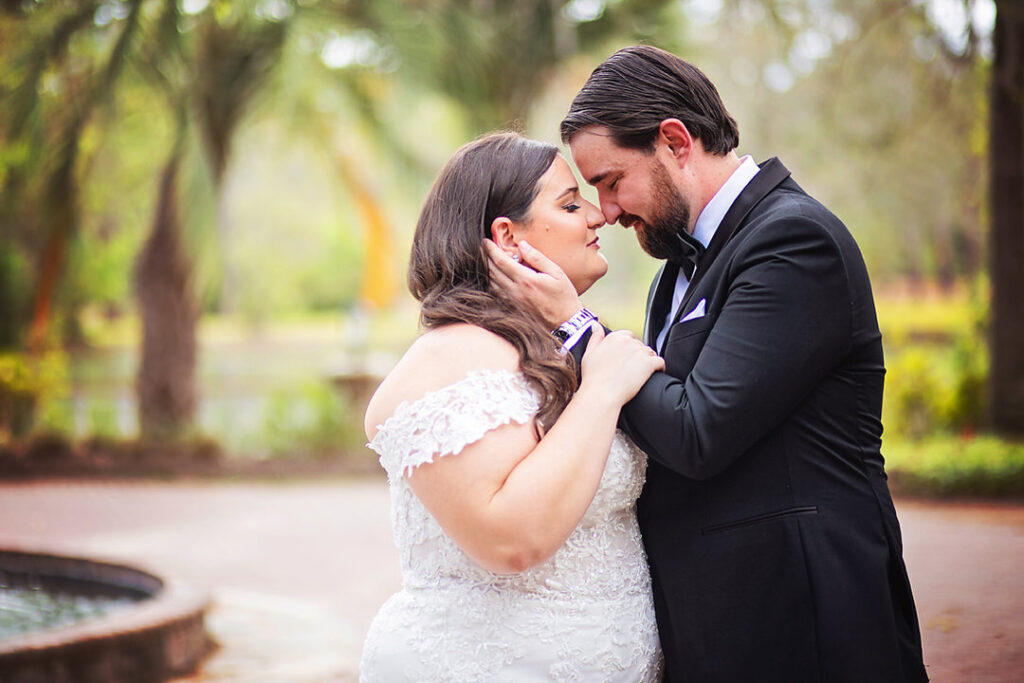 Bride and groom close eyes and touch noses with groom's hand on bride's face, and her hand on his arm in a garden setting - photographed by Charleston wedding photographer Luxe By Lindsay Photography