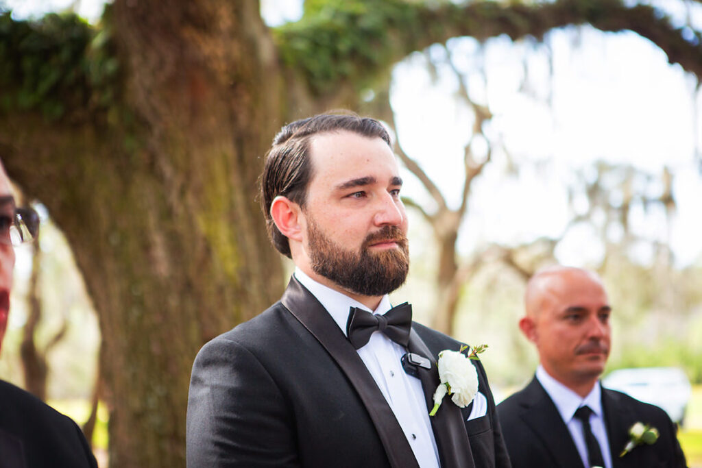 Groom's reaction to seeing the bride walk down the aisle at their wedding ceremony - photographed by Charleston wedding photographer Luxe By Lindsay Photography