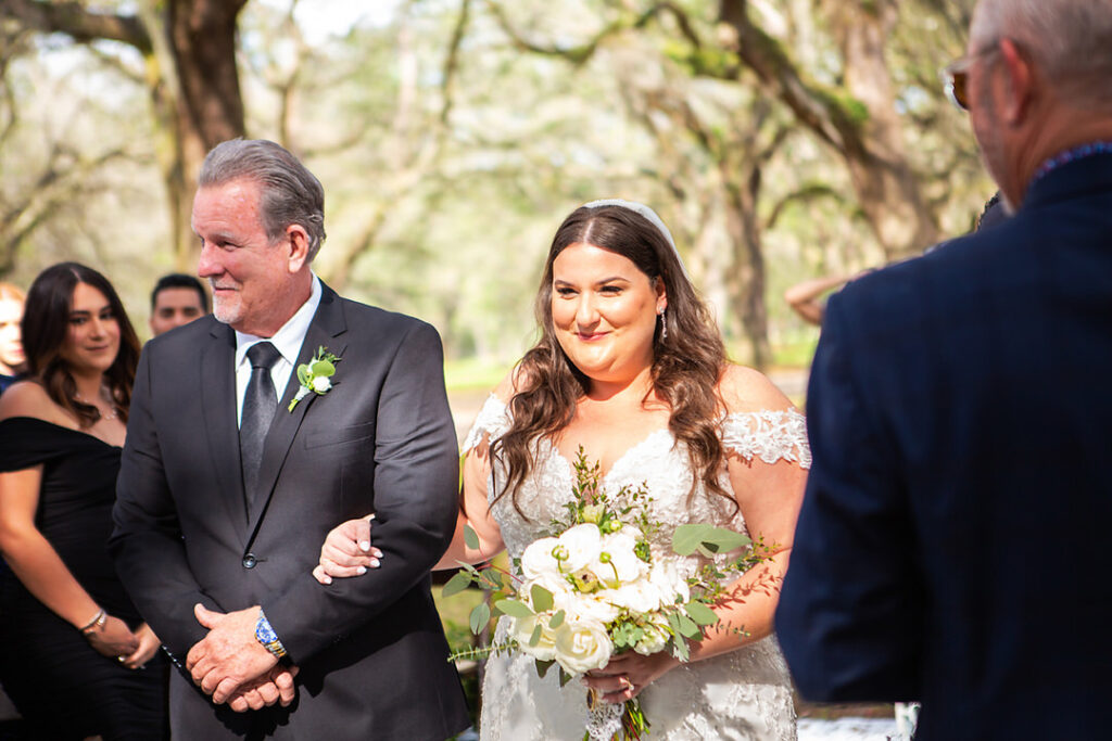 Close up of bride and father walking down the aisle to her wedding ceremony  - photographed by Charleston wedding photographer Luxe By Lindsay Photography