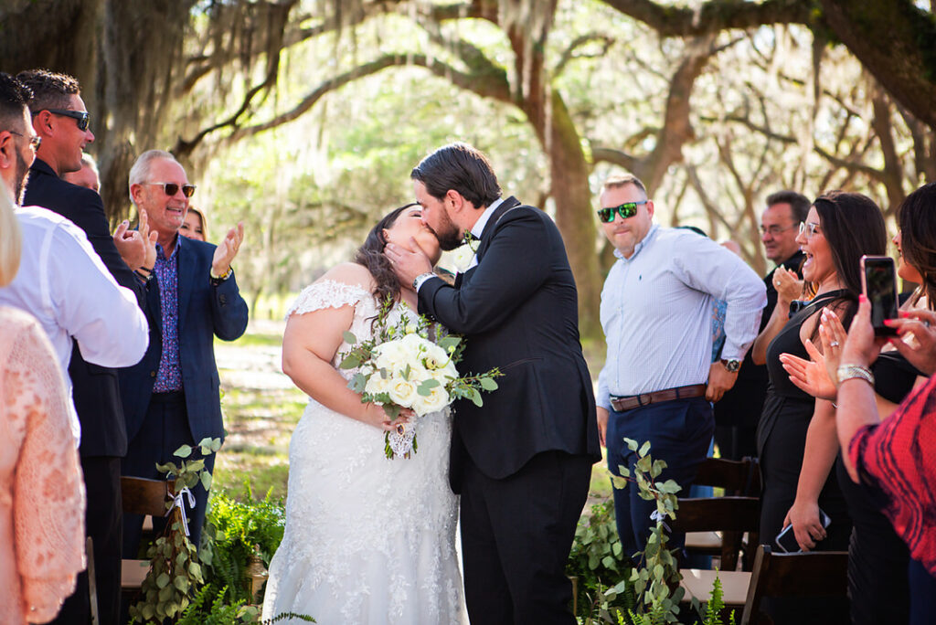 bride and groom kiss as they walk up the aisle during their wedding recessional at Eden at Gracefield - photographed by Charleston wedding photographer Luxe By Lindsay Photography