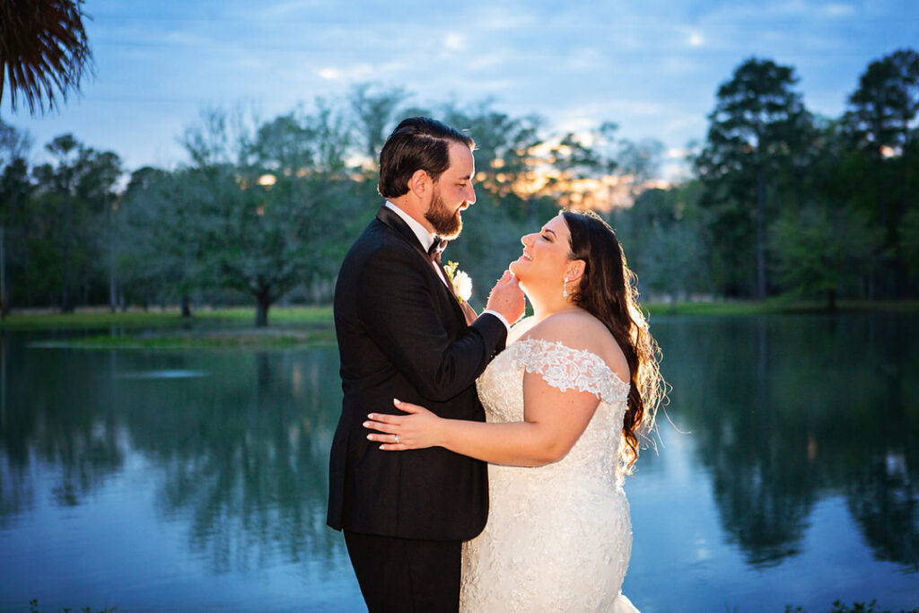 Bride and groom embrace and look at each other at dusk, in front of the lake at Eden at Gracefield - photographed by Charleston wedding photographer Luxe By Lindsay Photography